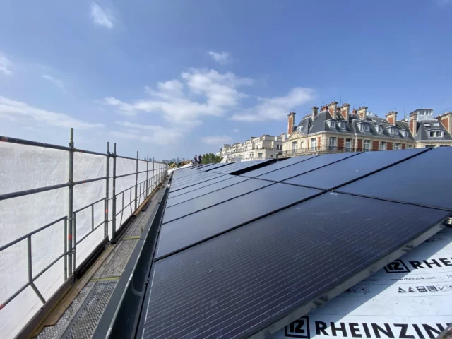 Technicien installant des panneaux solaires sur le toit de l'OCDE à Paris