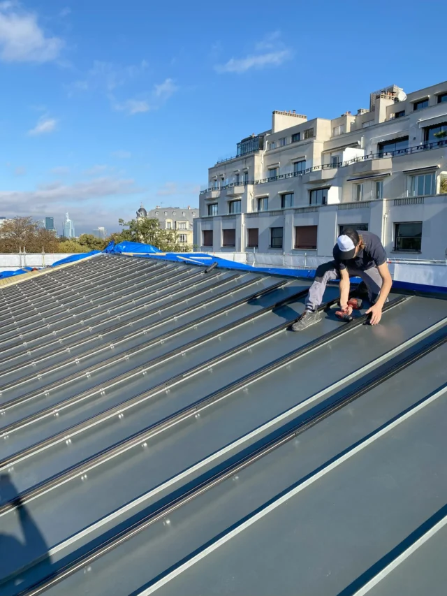 Installation des rails pour panneaux photovoltaïques sur le toit de l'OCDE à Paris.